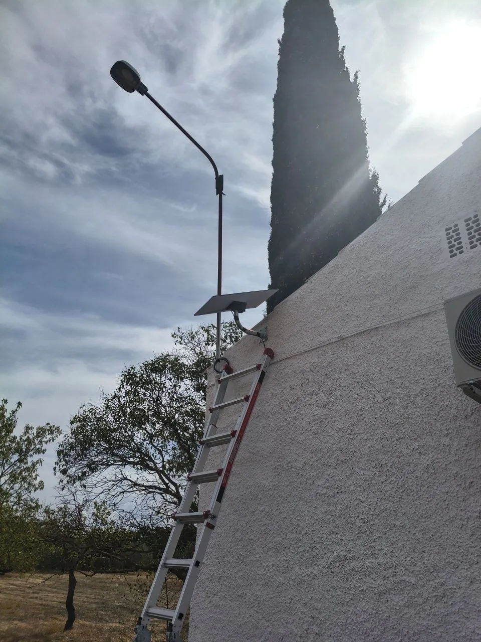 Antena Starlink Standard 4 instalada en una pared de Caudete, con un soporte corto en codo fijado a la fachada y una escalera apoyada debajo