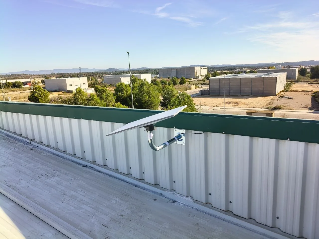 Antena Starlink Standard 4 instalada en el lateral de una nave industrial en Cheste, sobre un mástil de tubo galvanizado en codo